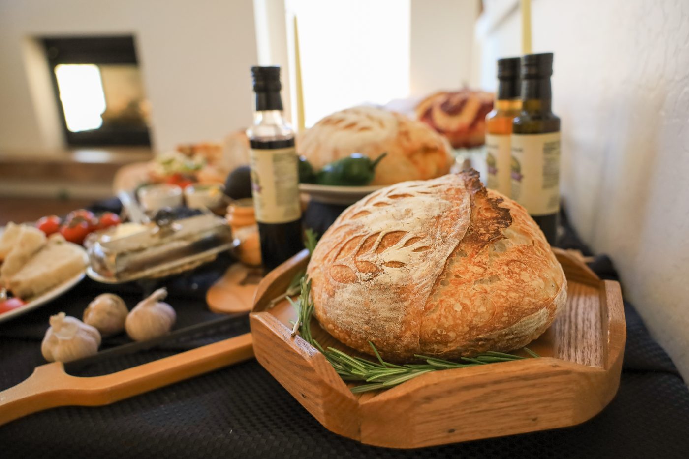 A garlic rosemary sourdough loaf, scored and baked to a deep crust