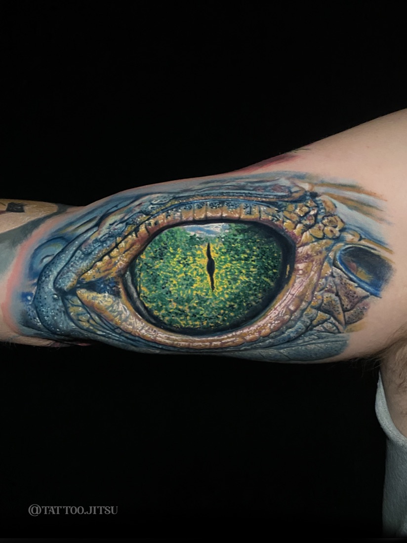 Hyper-realistic reptile eye tattoo in full color by Dan Mattingly